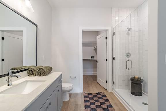 Bathroom with glass shower and walk-in closet at The Yancey Apartments, Charlotte, North Carolina
