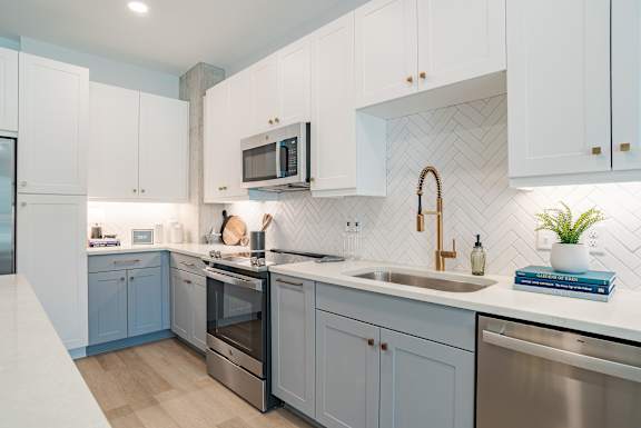 Contemporary kitchen with two tone cabinetry and gold fixtures at The Yancey Apartments, North Carolina, 28217