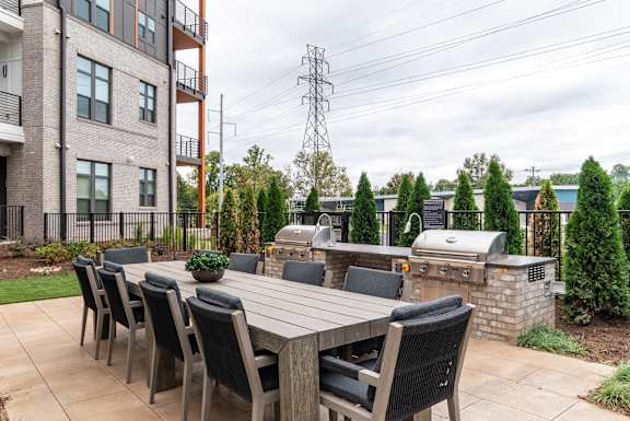 Outdoor kitchen and dining area with grilling stations at The Yancey Apartments, Charlotte, NC 28217
