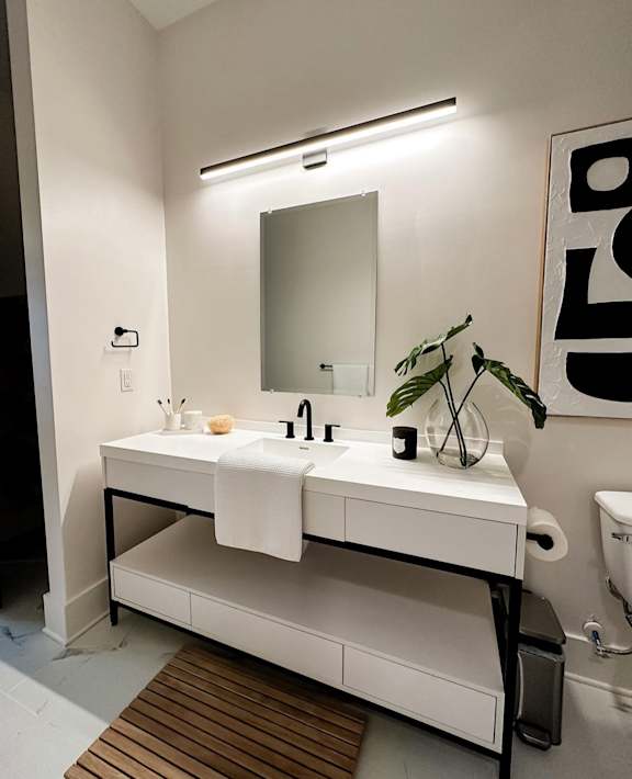 A white bathroom with a sink and mirror.