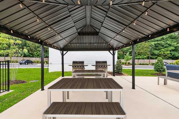 A covered patio with a table and chairs.