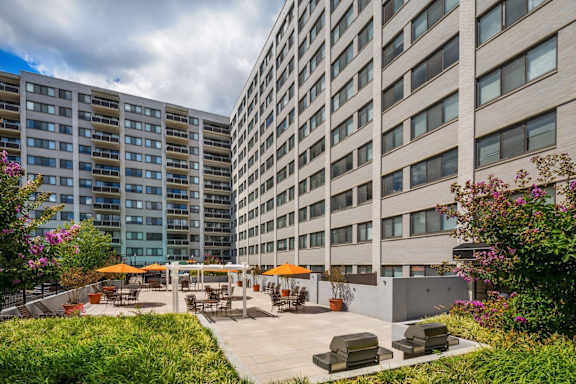A large building with a patio area in front of it.