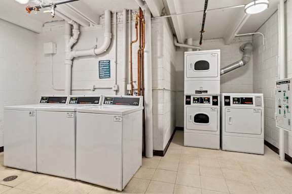 A series of industrial ovens and pipes in a clean, white room.