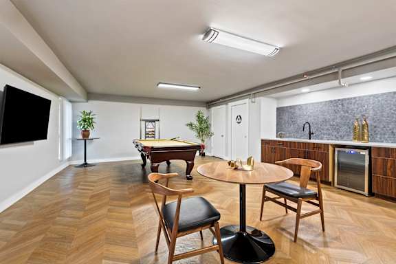 A room with a pool table and a television.