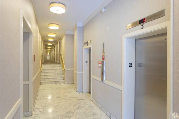 A long hallway with a staircase and elevator doors.