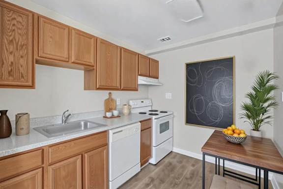 A kitchen with wooden cabinets and a white dishwasher.
