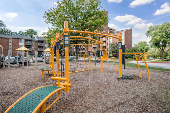 A playground with a yellow and green slide and a yellow and green climbing structure.at Aspen at Lake Trail, Columbia, 21045