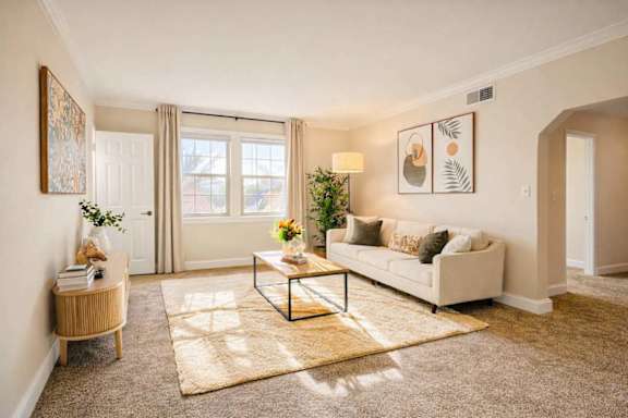 A living room with a white couch, a coffee table, and a rug.