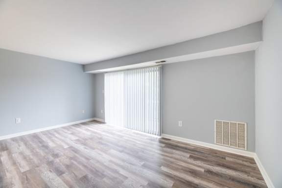 A room with wooden flooring and a window with blinds at BellaVista Apartments in Woodbridge, VA