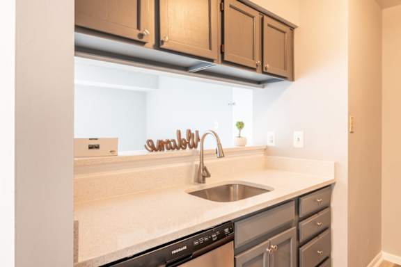 A kitchen with a stainless steel sink and a black dishwasher at BellaVista Apartments in Woodbridge, VA