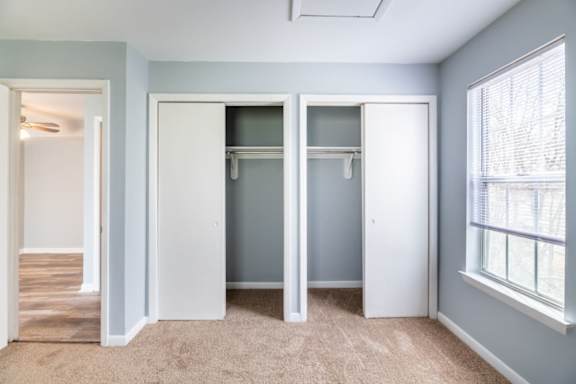 A room with a carpeted floor and a window with blinds at BellaVista Apartments in Woodbridge, VA