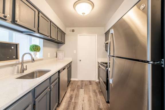 A kitchen with a stainless steel refrigerator and black cabinets at BellaVista Apartments in Woodbridge, VA