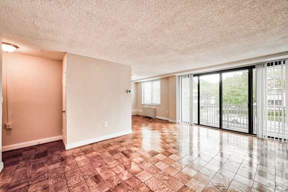 A room with a tile floor and sliding glass doors at The Brittany, Washington, DC, 20015