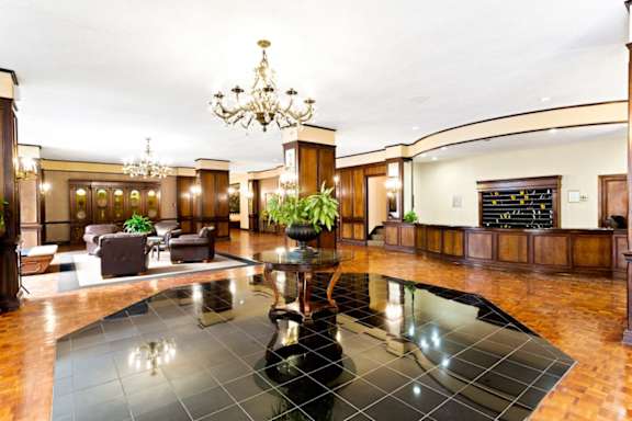 A large, elegant room with a chandelier, a pool table, and a couch.