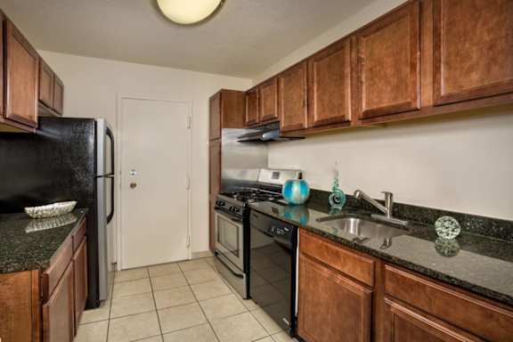 A kitchen with black appliances and wooden cabinets.
