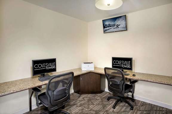 Two black chairs are in front of two signs that say Colesville Towers.