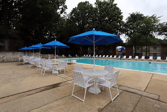 A poolside area with chairs and umbrellas.