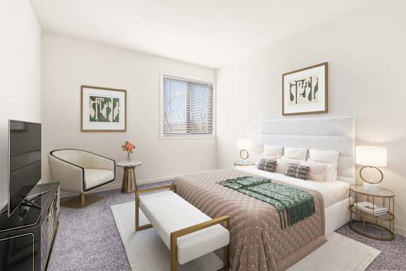 A bedroom with a large bed, a chair, and a TV.