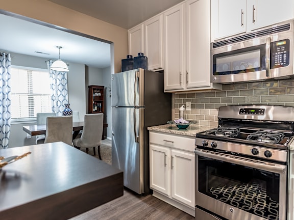 A modern kitchen with a stainless steel refrigerator, oven, and microwave.