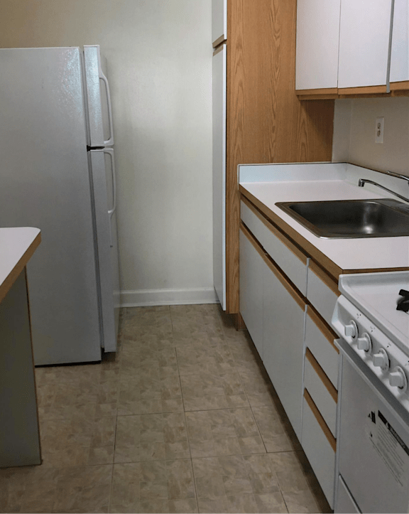 A kitchen with a white fridge, white oven and white sink.