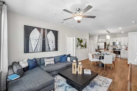 A modern living room with a grey sofa and a large abstract painting on the wall.