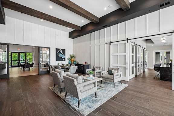 A modern living room with a grey sofa set and wooden floors.