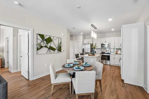 A modern kitchen with a dining table set for two.