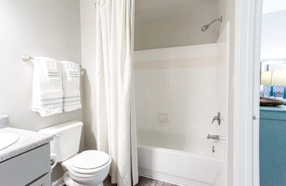 A white bathroom with a toilet, sink, and bathtub.