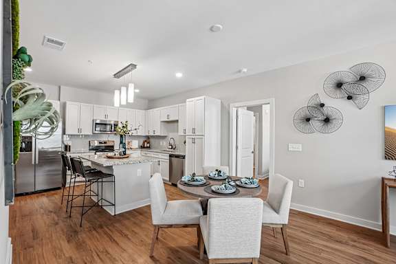 A kitchen with a table set for two with a view of the back of the room.