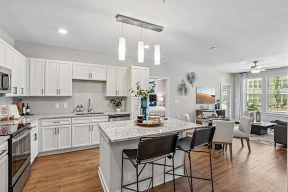 A modern kitchen with a center island and a dining area.