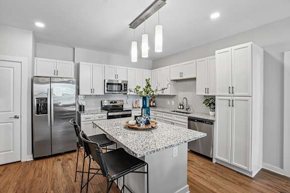 A kitchen with a granite countertop and stainless steel appliances.