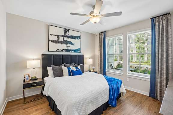 A bedroom with a large bed and a ceiling fan.