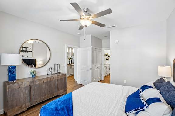 A bedroom with a bed, a dresser, and a mirror.