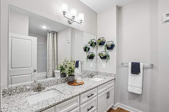 A bathroom with a marble countertop and a large mirror.