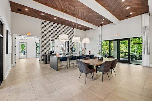 A modern dining room with a wooden ceiling and a black and white checkered wall.