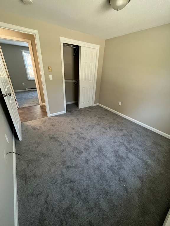 A room with a carpeted floor and two doors.