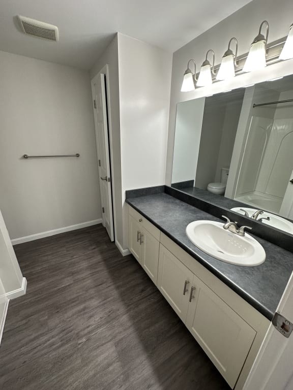 an empty bathroom with a sink and a mirror at Carisbrooke at Manchester Apartments, New Hampshire, 03102