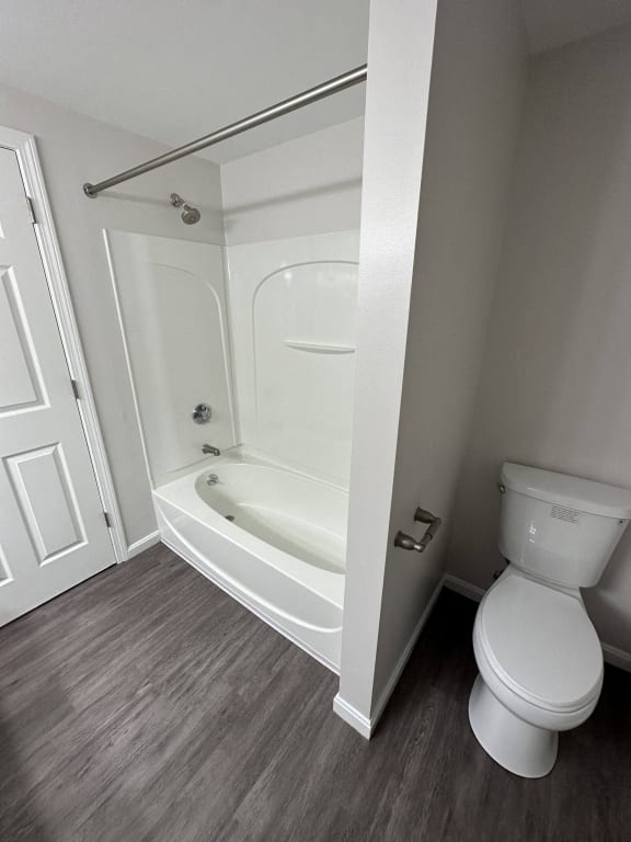 a small bathroom with a toilet and a bath tub at Carisbrooke at Manchester Apartments, Manchester, NH