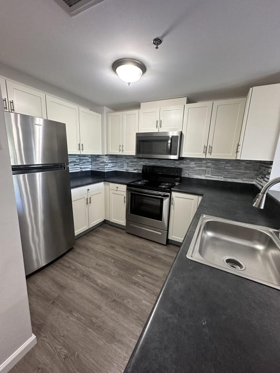 a kitchen with stainless steel appliances and white cabinets  at Carisbrooke at Manchester Apartments, Manchester, NH