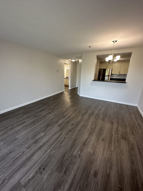 an empty living room with wood floors and white walls at Carisbrooke at Manchester Apartments, Manchester