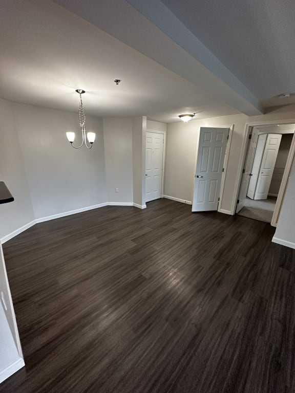 an empty living room with wood floors and white walls at Carisbrooke at Manchester Apartments, Manchester, New Hampshire