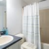 a bathroom with a shower and a sink and a mirror at Carisbrooke at Manchester Apartments, Manchester, NH