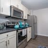 a kitchen with a stove and a microwave and a refrigerator at Carisbrooke at Manchester Apartments, New Hampshire