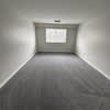 a empty room with a window and a wooden floor at Carisbrooke at Manchester Apartments, Manchester, New Hampshire