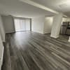 an empty living room with a wooden floor at Carisbrooke at Manchester Apartments, Manchester, NH