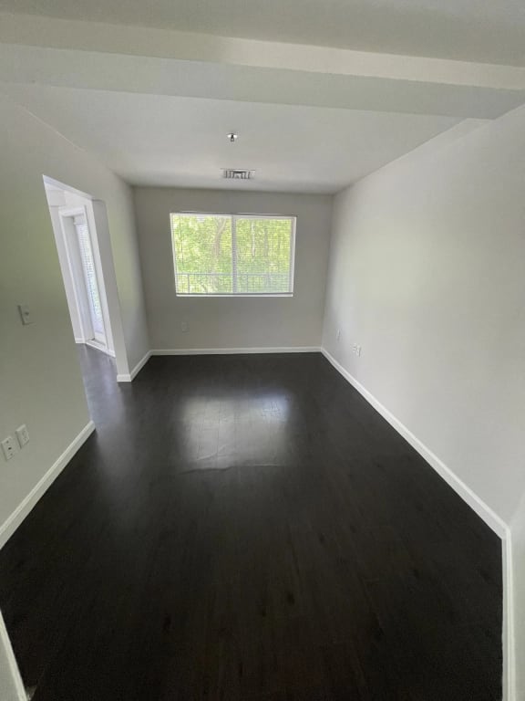 a empty room with wooden floors and a window at Carisbrooke at Manchester Apartments, Manchester, NH