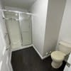 a white bathroom with a toilet and a shower at Carisbrooke at Manchester Apartments, New Hampshire