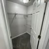 a bathroom with a closet and a white door at Carisbrooke at Manchester Apartments, Manchester, 03102