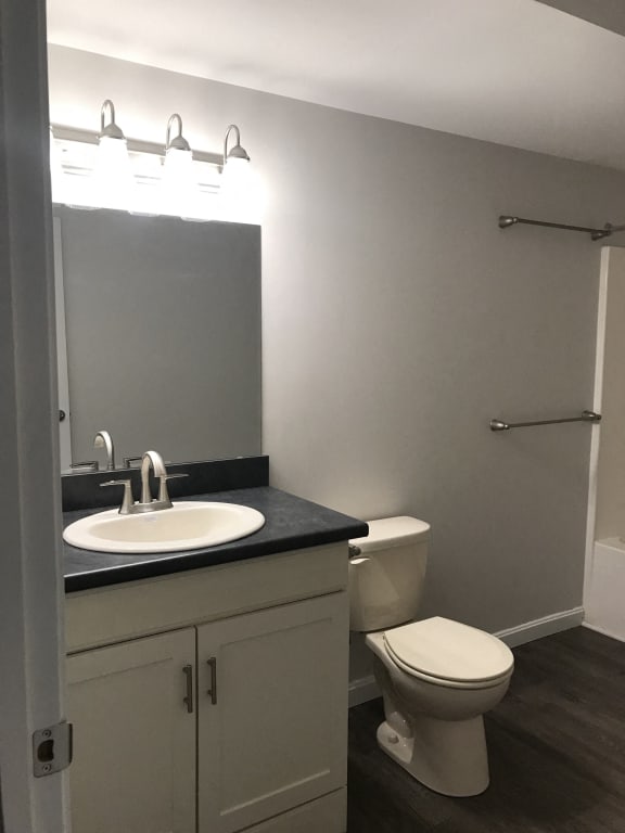 a bathroom with a sink toilet and a mirror at Carisbrooke at Manchester Apartments, Manchester