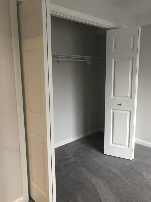 a walk in closet with a white door and a carpet at Carisbrooke at Manchester Apartments, New Hampshire, 03102